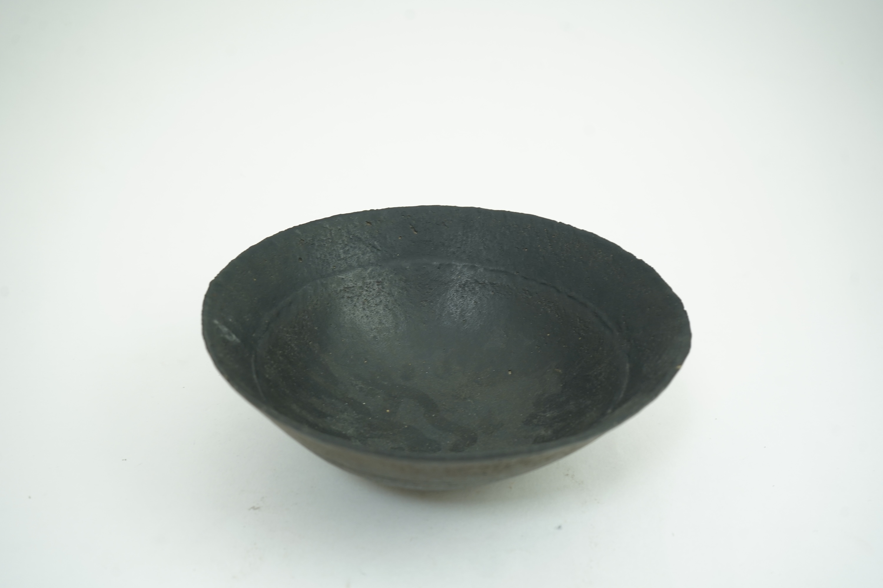 John Ward (1938-2023): A hand-built stoneware black glazed bowl with irregular rim